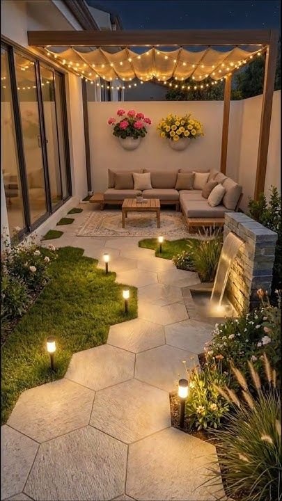Terraza nocturna con sofá y pérgola iluminada